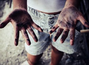 Dirty hands of children from construction work. World Day Against Child Labour concept.